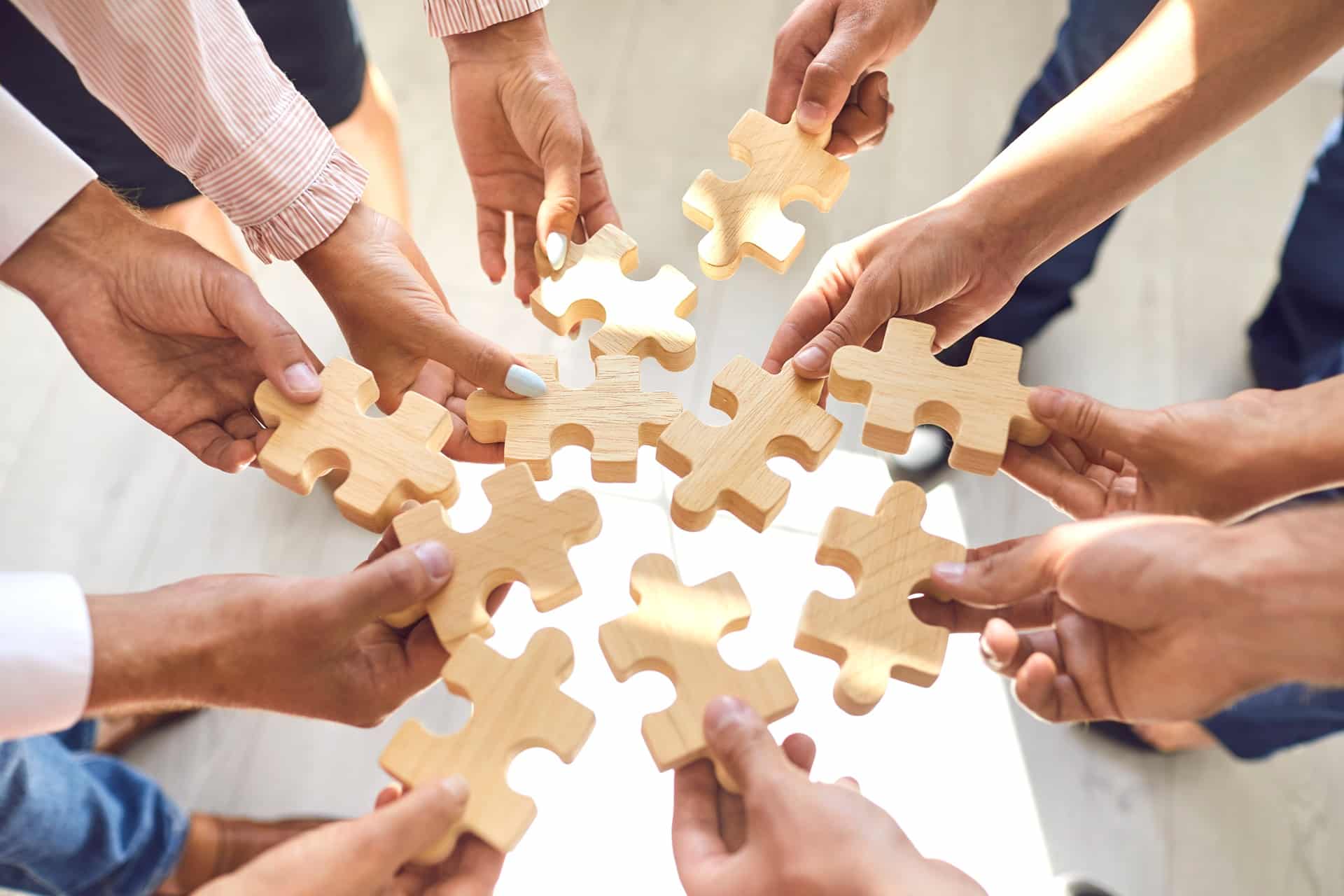 Haende mit Puzzleteilen im Kreis | Eventmoderator