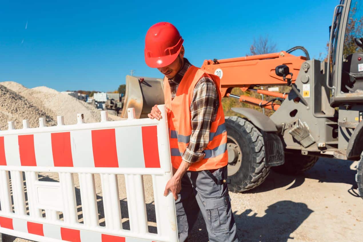 Verkehrsabsicherung auf Baustelle mit Bauarbeiter und Absperrelementen