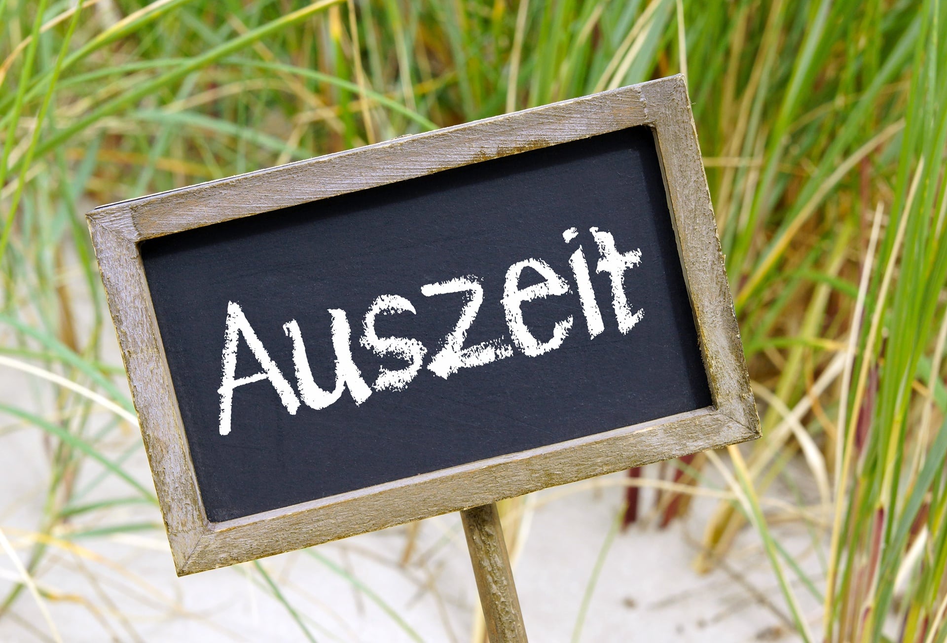 Holzschild mit Auszeit im Gras | Erlebnisbauernhof NRW