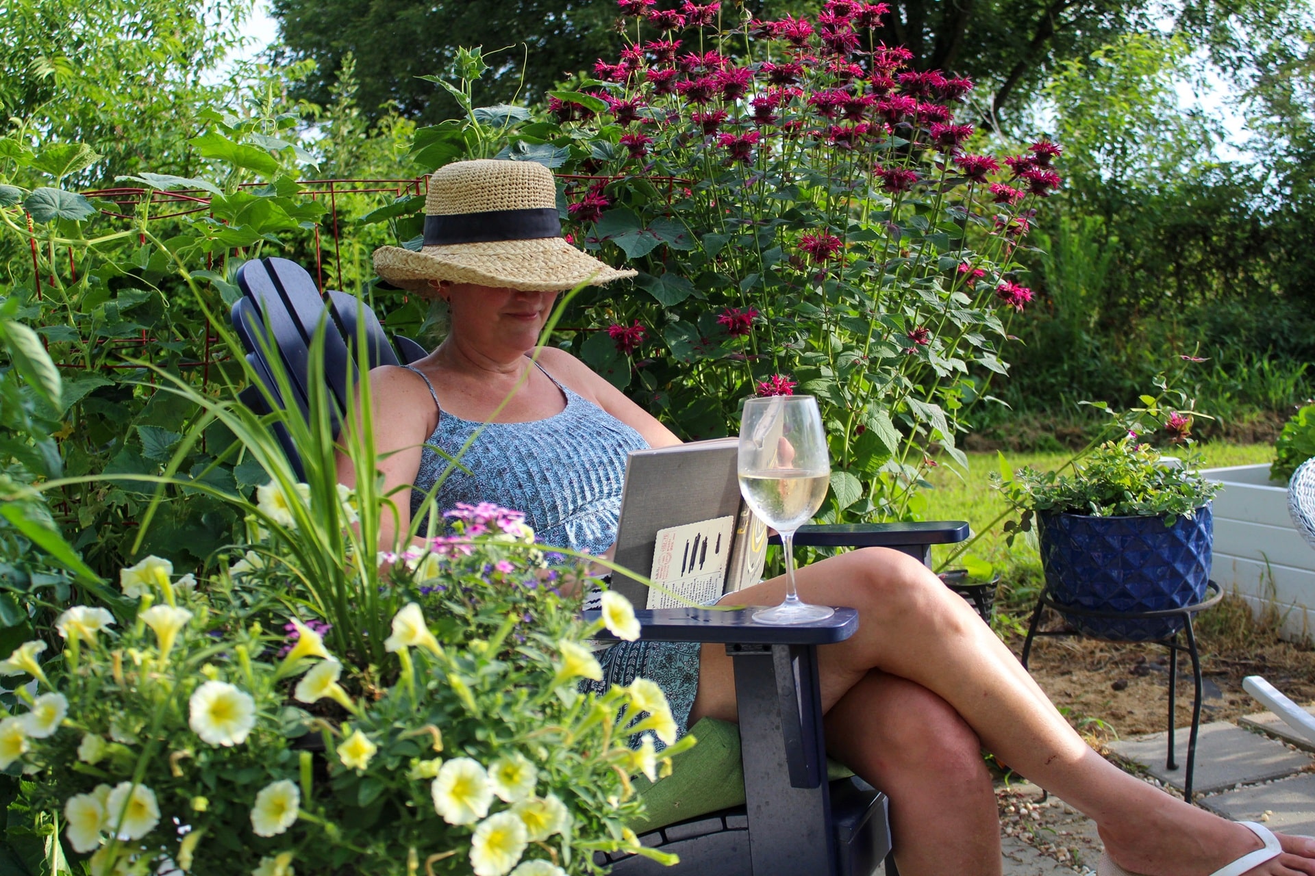 Lesende Frau im Garten mit Wein und Blumen | Stegplatten kaufen 